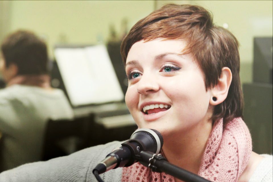 A singer smiling at a microphone