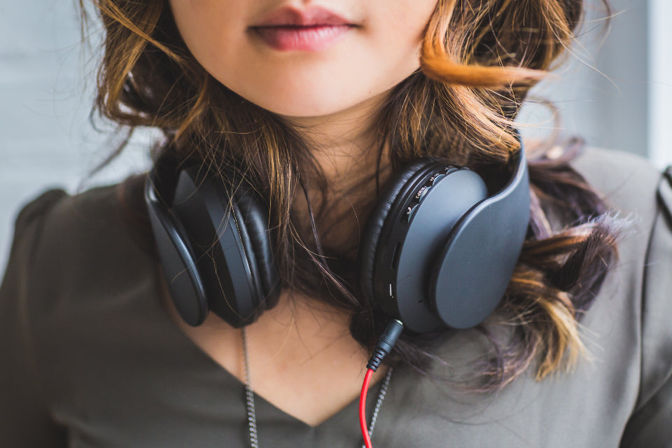 A woman wearing headphones around her neck