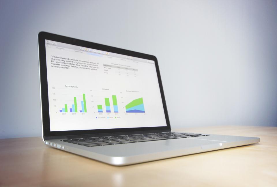 A laptop showing charts on a desk