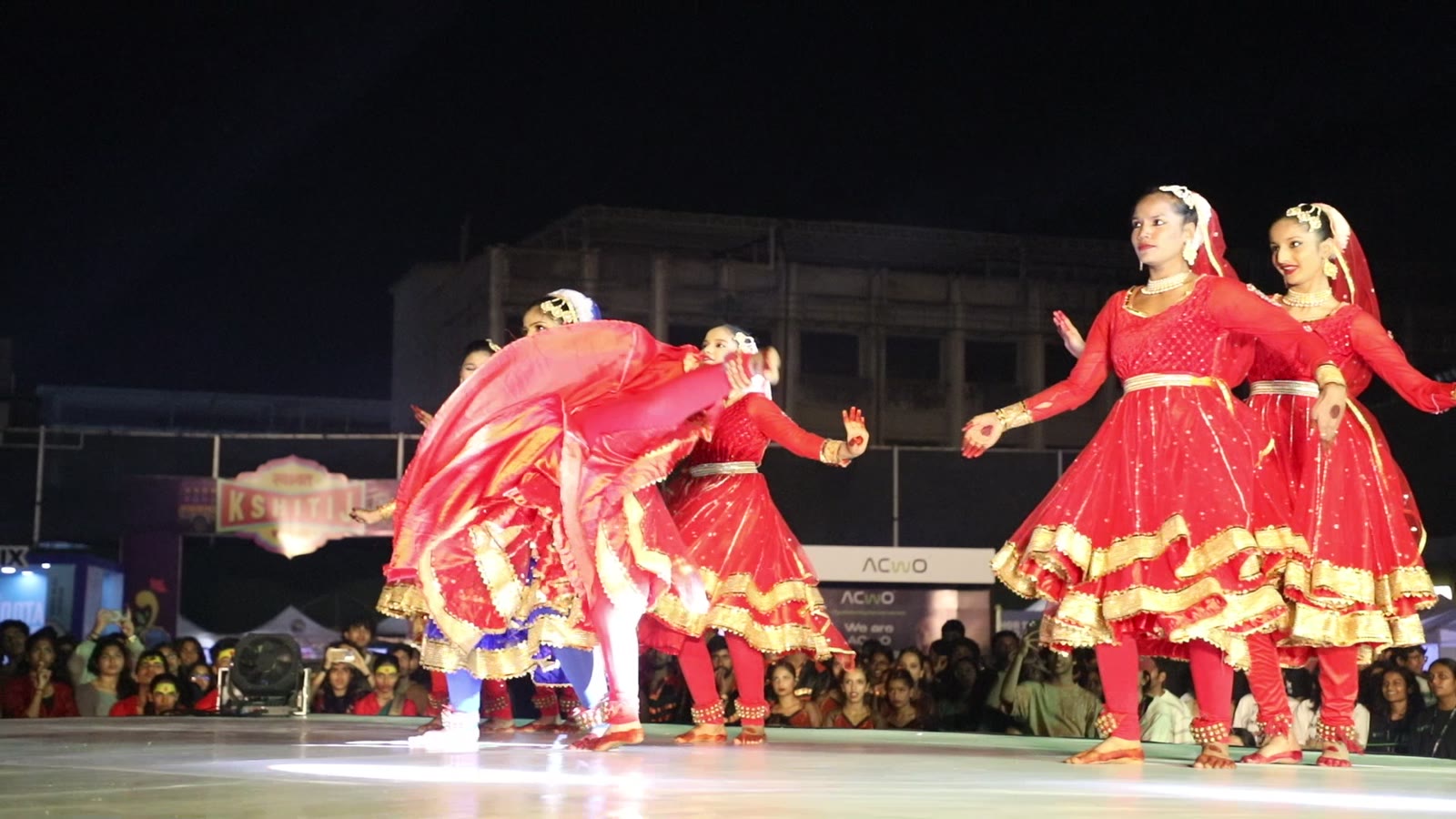 A dance ensemble performing in red lehengas