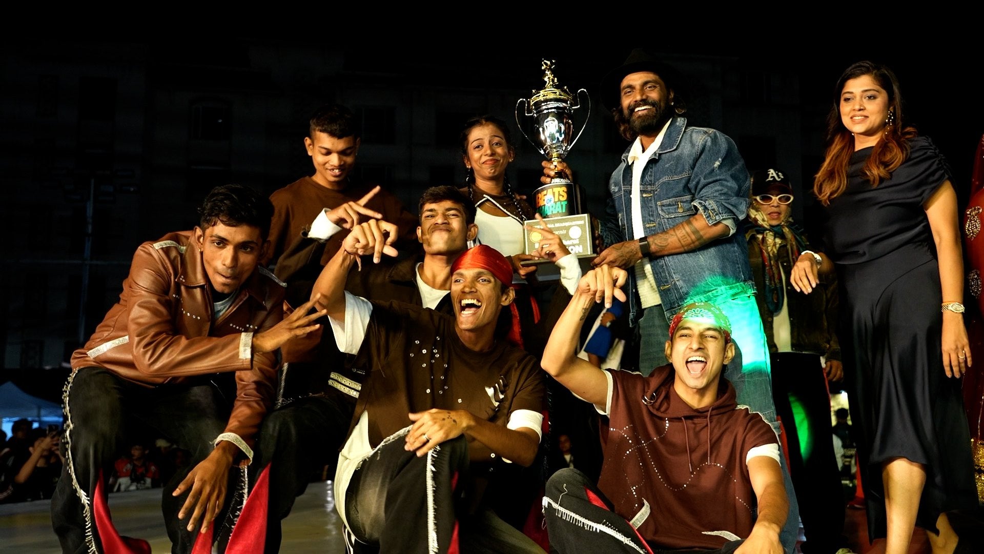 A dance crew celebrating with their trophy