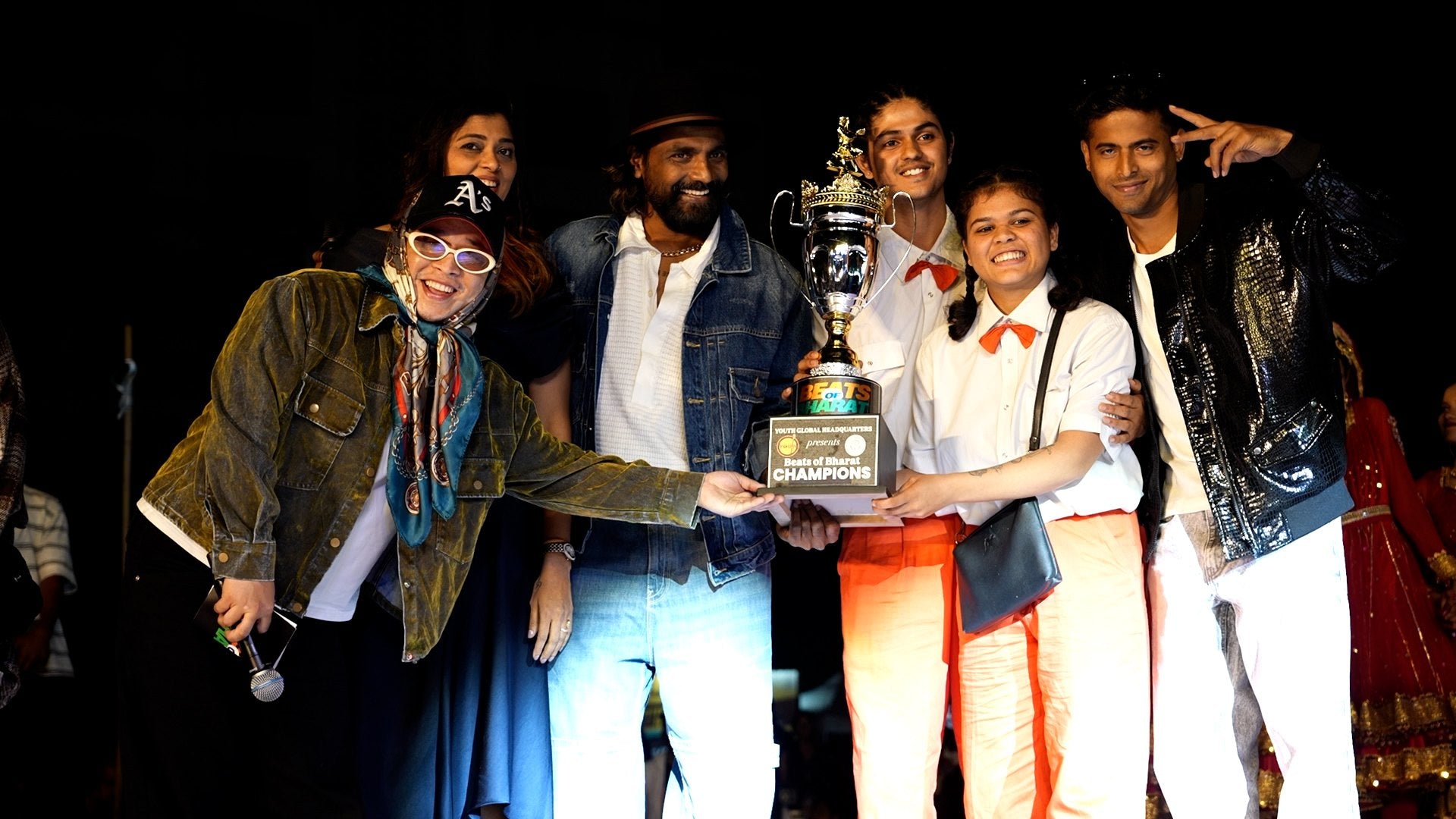 A dance crew lifting the trophy