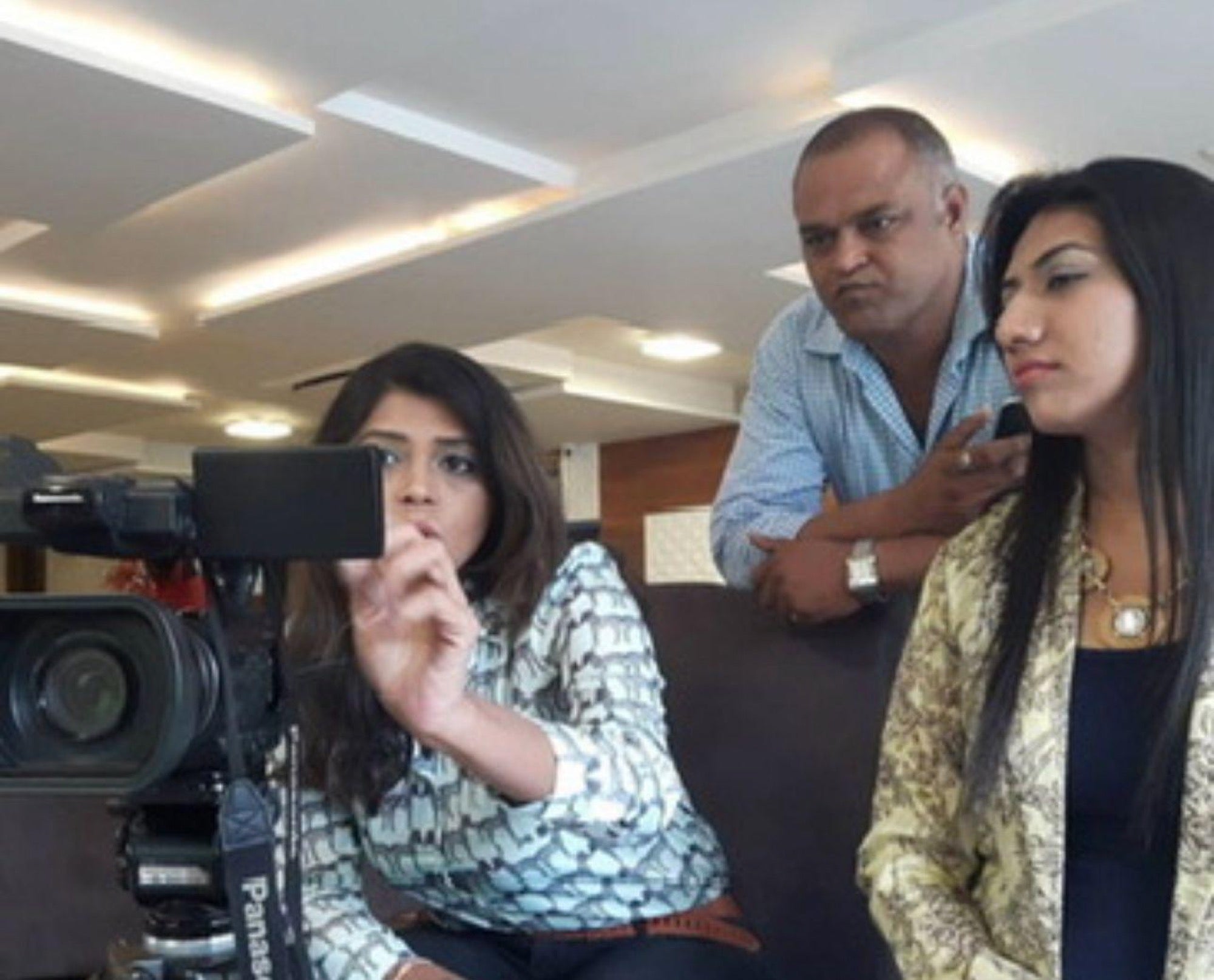 A crew watching a monitor on location