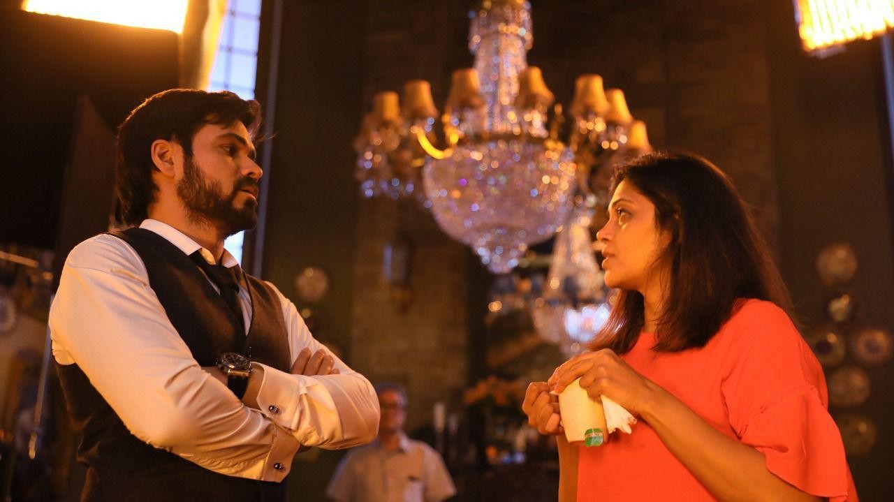 A director talking with her lead actor between takes on a film set