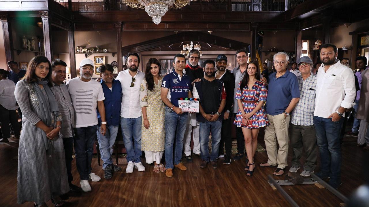 Cast and crew together on set with the clapboard