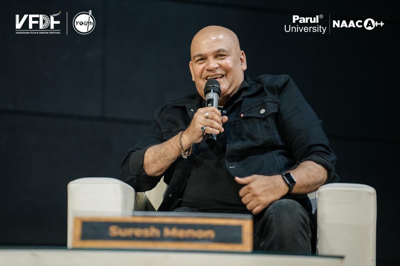 Suresh Menon laughing on stage at the Vadodara Film & Design Festival